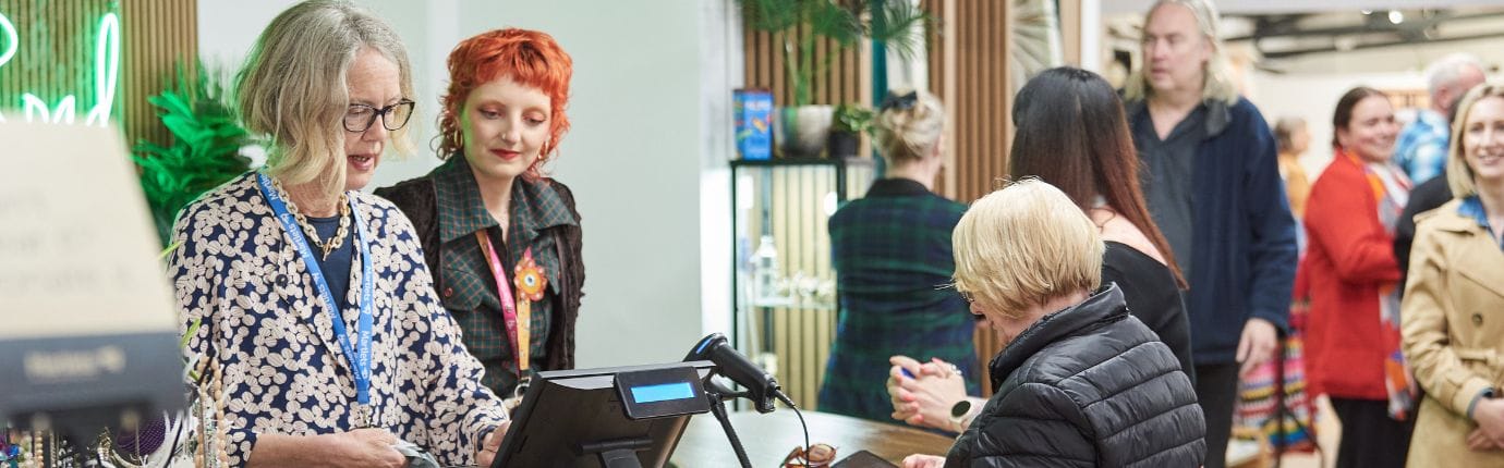 Interior image of the MArtlets Charity shop with staff and volunteers serving customers