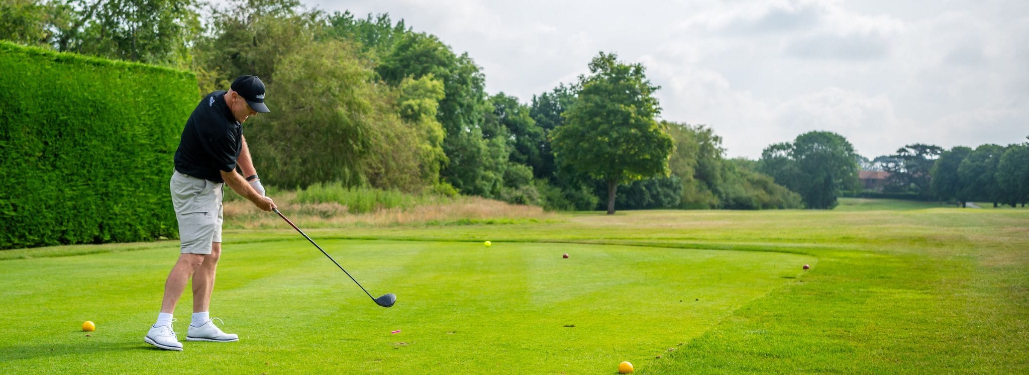 golfer mid swing at a charity golf day at ham manor golf club